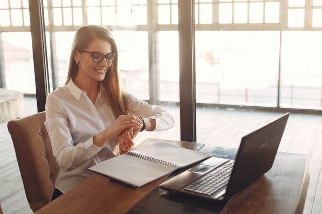 A happy business woman checking the time