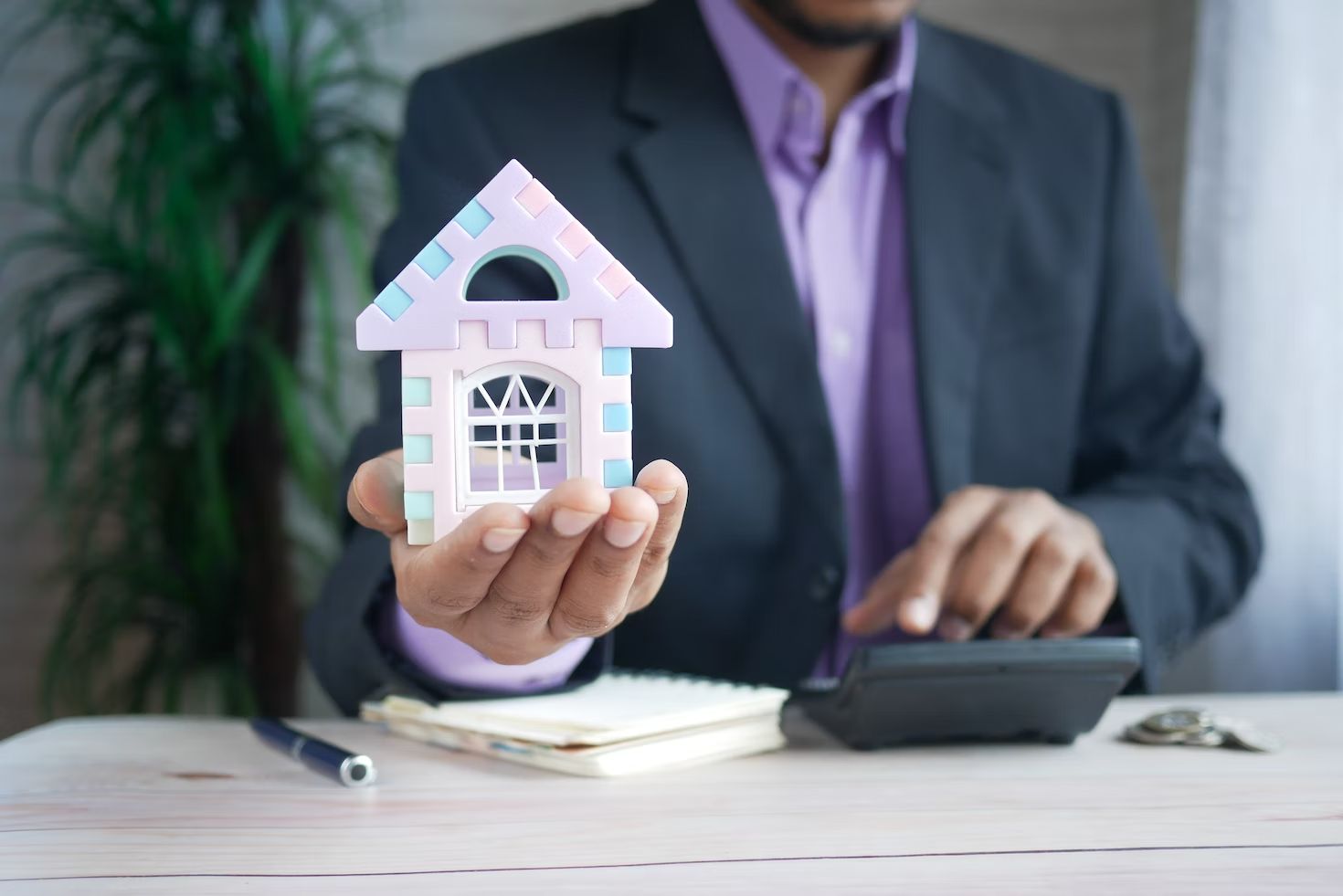 Business man holding tiny model of home