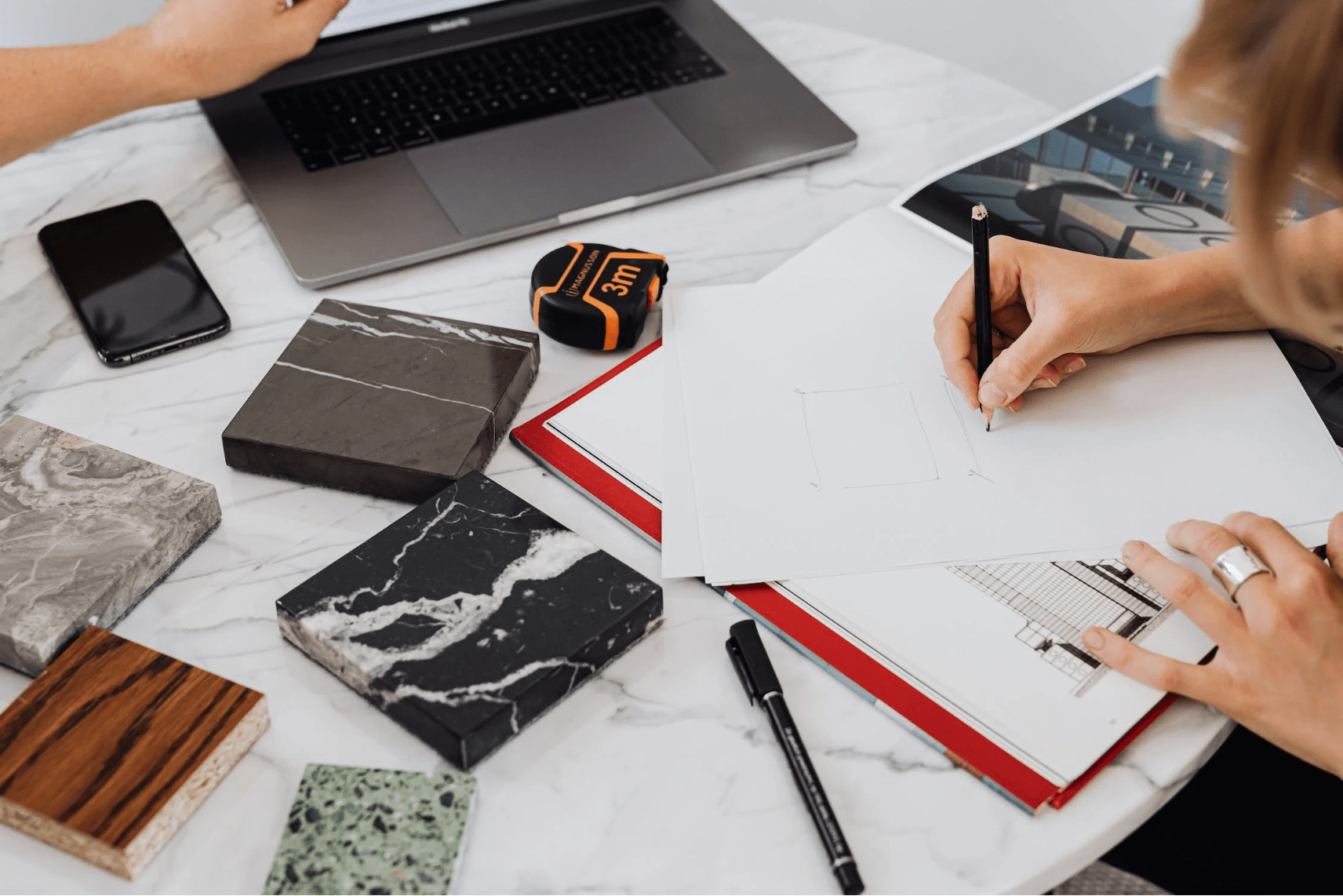 hand making notes next to a selection of materials